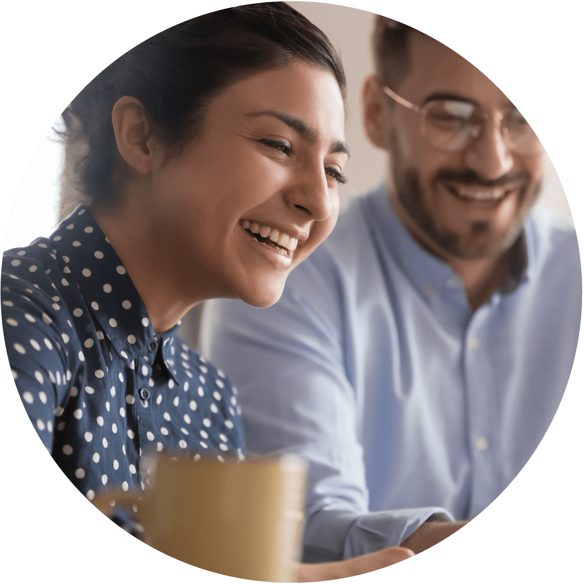 Two people laughing while looking at something together - wellbeing and connection at work.